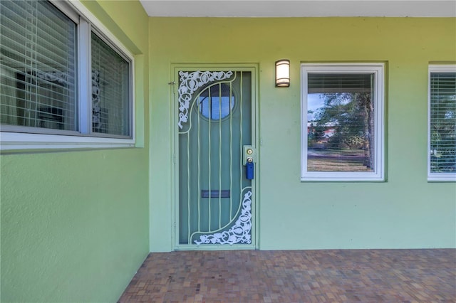 property entrance with stucco siding