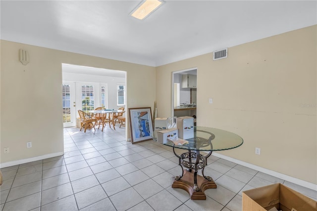 interior space with light tile patterned floors and french doors