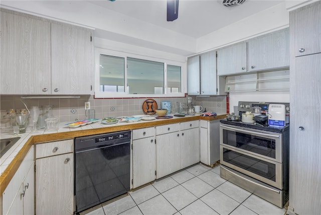 kitchen with tasteful backsplash, tile countertops, light tile patterned floors, dishwasher, and range with two ovens