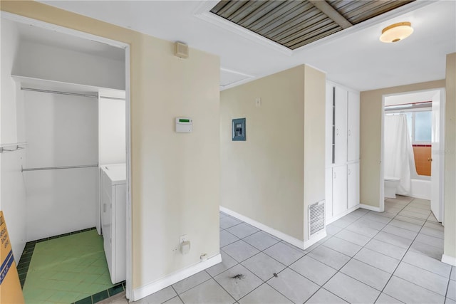 hallway with washer / clothes dryer and light tile patterned flooring