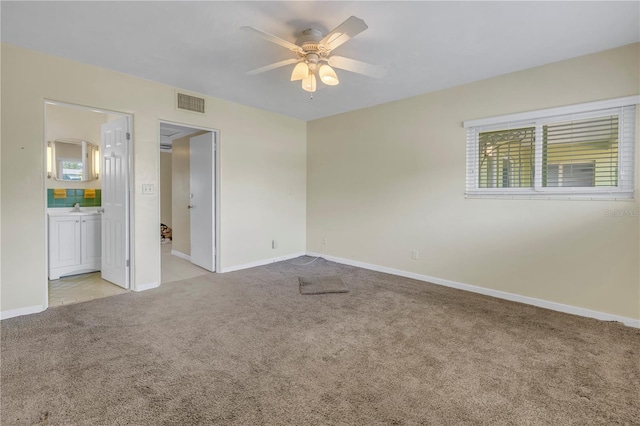 spare room with ceiling fan, sink, and light carpet