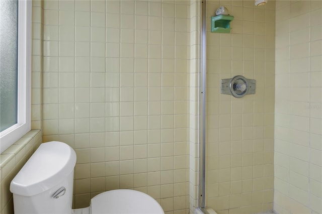 bathroom with tiled shower, tile walls, and toilet