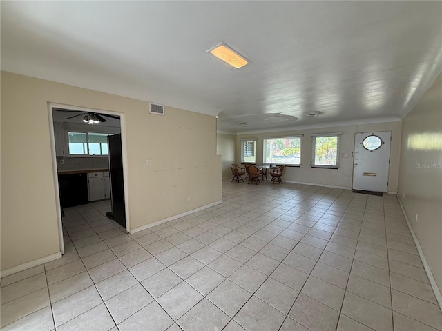 interior space with a healthy amount of sunlight, light tile patterned floors, baseboards, and visible vents