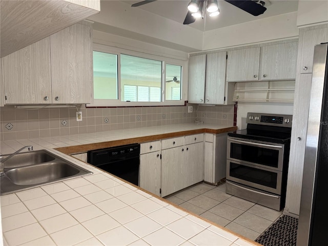 kitchen featuring black dishwasher, decorative backsplash, double oven range, a sink, and light tile patterned flooring