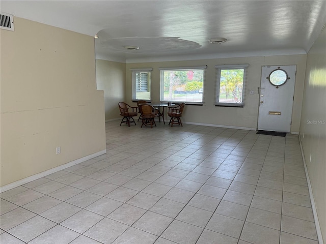 interior space featuring light tile patterned floors, visible vents, and baseboards