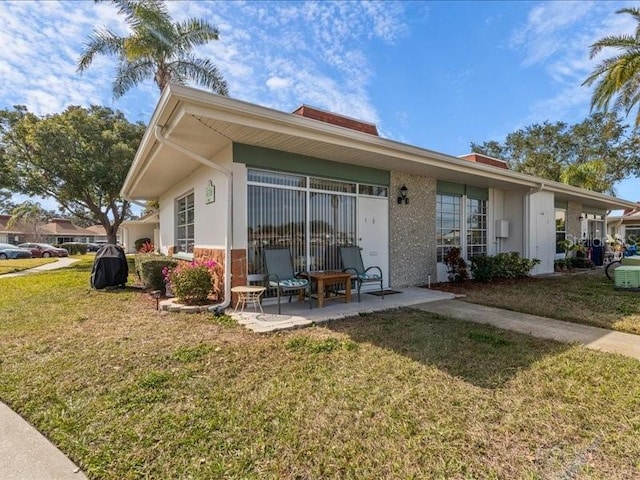 back of property with a yard and a patio area