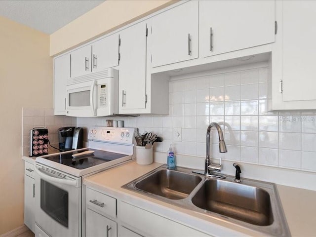 kitchen with backsplash, white appliances, sink, and white cabinets