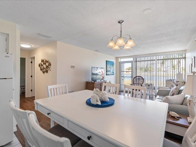 dining area with a textured ceiling and a chandelier