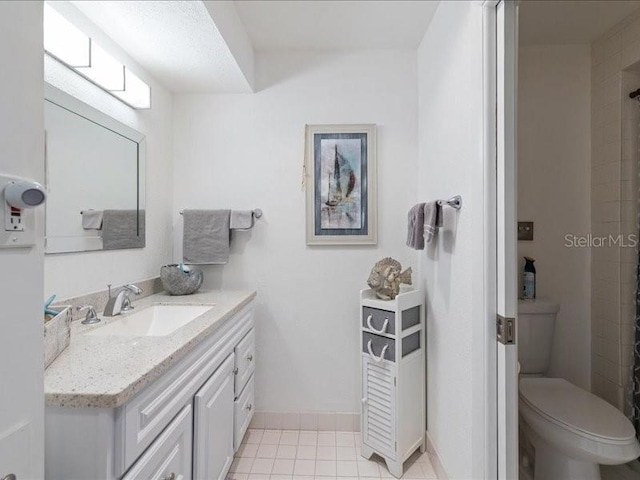 bathroom featuring vanity, tile patterned flooring, and toilet