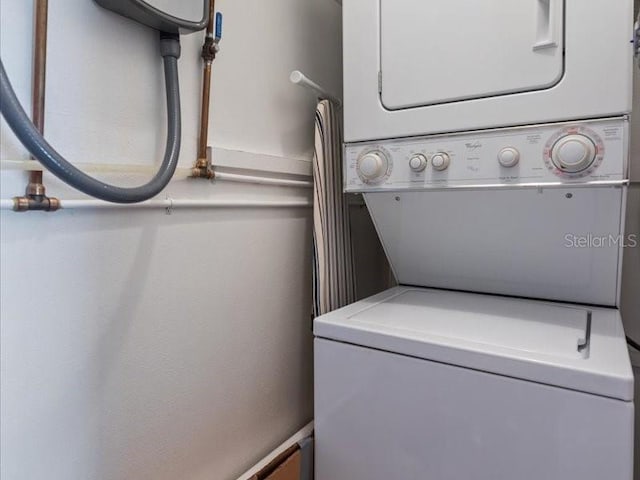 clothes washing area with stacked washer and clothes dryer