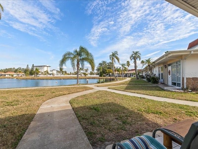 view of community featuring a water view and a yard