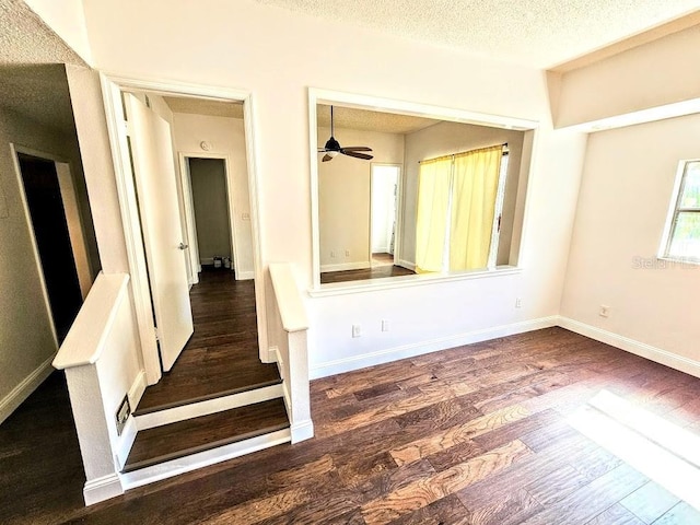 interior space with a textured ceiling and dark hardwood / wood-style flooring