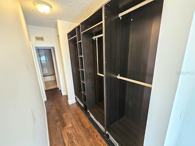 spacious closet with dark wood-type flooring