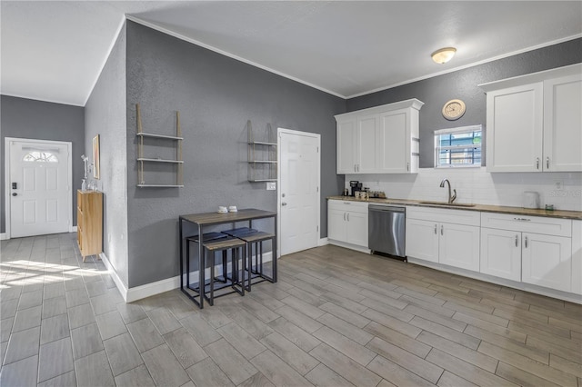 kitchen featuring sink, wooden counters, white cabinets, decorative backsplash, and stainless steel dishwasher