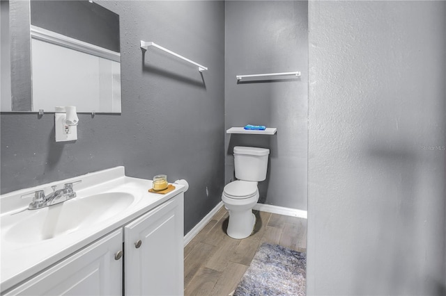 bathroom with vanity, wood-type flooring, and toilet