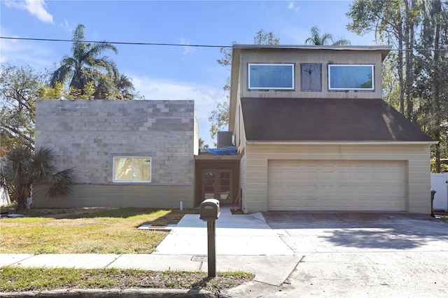 view of property featuring a garage and central air condition unit