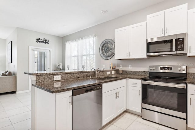 kitchen with white cabinetry, appliances with stainless steel finishes, kitchen peninsula, and sink