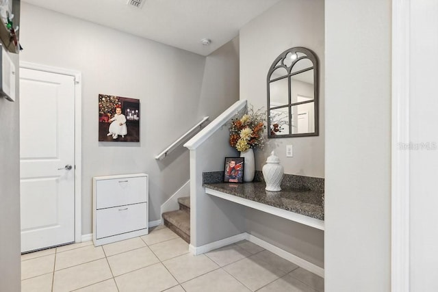 stairway with tile patterned floors