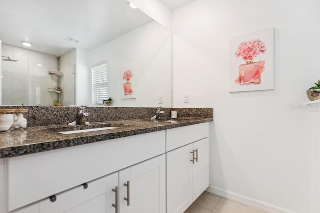 bathroom with walk in shower, vanity, and tile patterned flooring