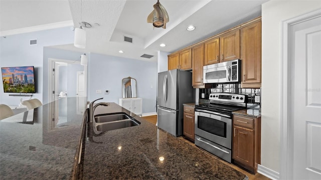 kitchen featuring sink, stainless steel appliances, and dark stone counters