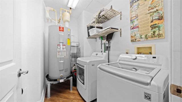 washroom with washer and dryer, hardwood / wood-style flooring, and electric water heater