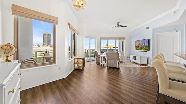 interior space with crown molding, ceiling fan with notable chandelier, and dark hardwood / wood-style flooring