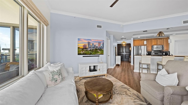 living room with ornamental molding, dark hardwood / wood-style floors, and ceiling fan