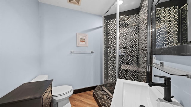 bathroom featuring hardwood / wood-style flooring, a shower with door, sink, and toilet