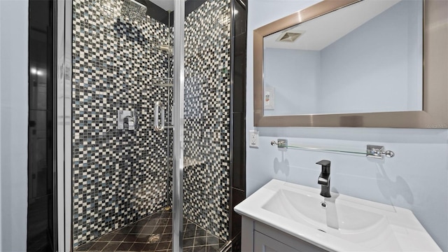 bathroom featuring a shower with door and vanity