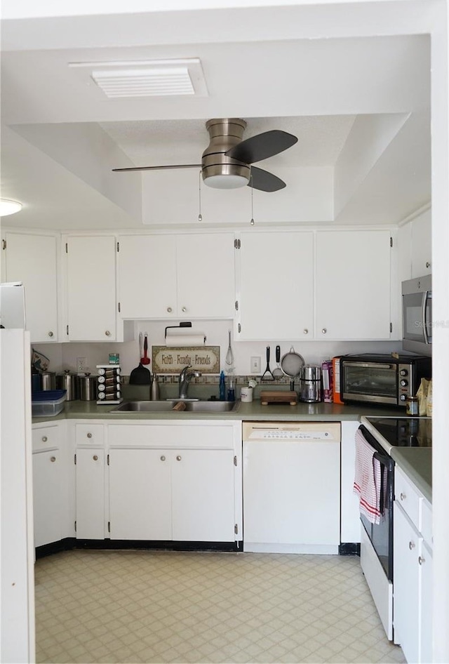 kitchen with white cabinetry, sink, white appliances, and ceiling fan