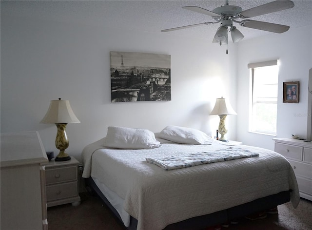 carpeted bedroom with ceiling fan and a textured ceiling