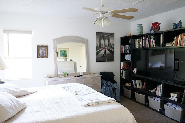 bedroom featuring ceiling fan, carpet, and a textured ceiling