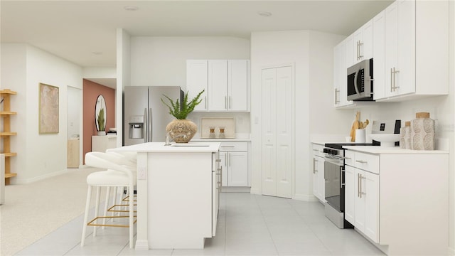 kitchen with a breakfast bar, white cabinetry, a center island, light tile patterned floors, and stainless steel appliances