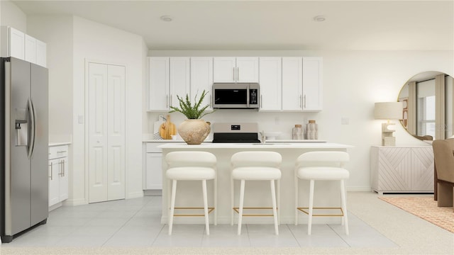 kitchen featuring white cabinetry, stainless steel appliances, a kitchen breakfast bar, and light tile patterned floors