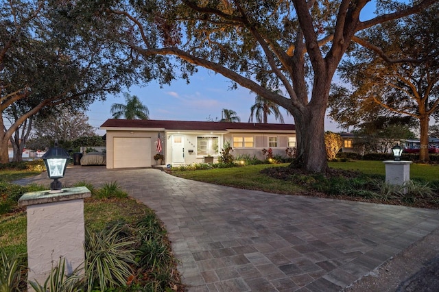 ranch-style house featuring a yard and a garage