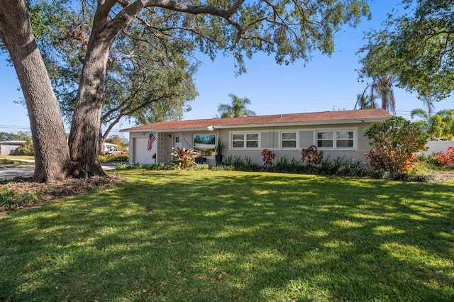 ranch-style home featuring a garage and a front lawn