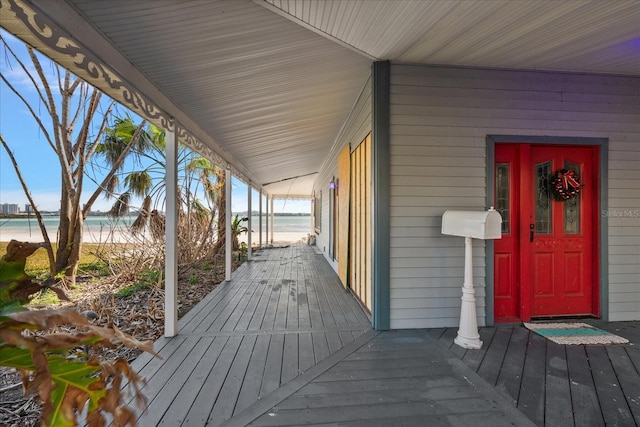 wooden deck with a porch and a water view