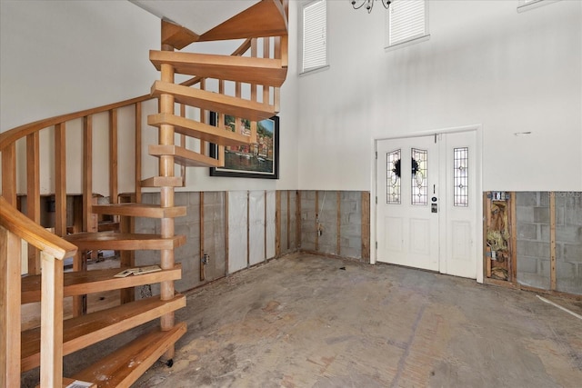 entryway with concrete flooring and a high ceiling