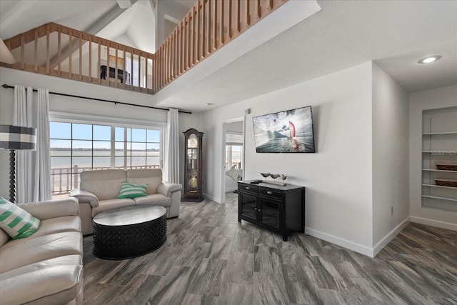 living room with a towering ceiling and dark wood-type flooring