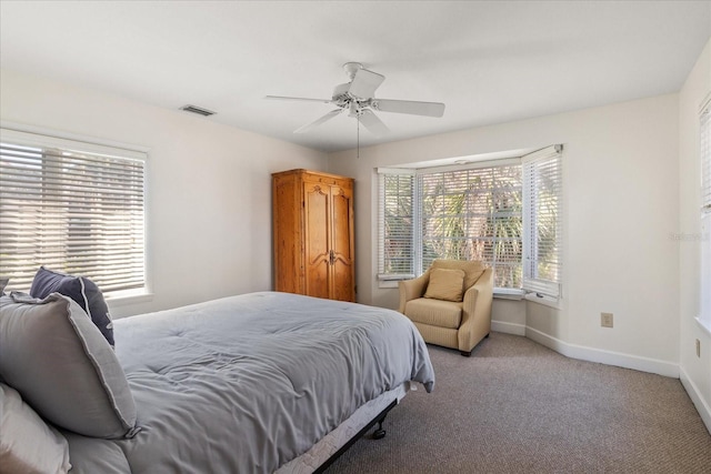 carpeted bedroom featuring ceiling fan and multiple windows