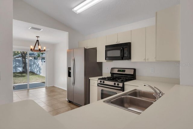 kitchen featuring sink, decorative light fixtures, vaulted ceiling, a notable chandelier, and stainless steel appliances