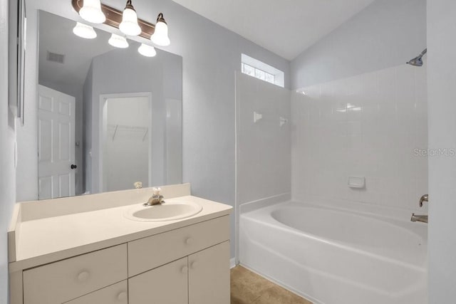 bathroom with vanity, lofted ceiling, and washtub / shower combination