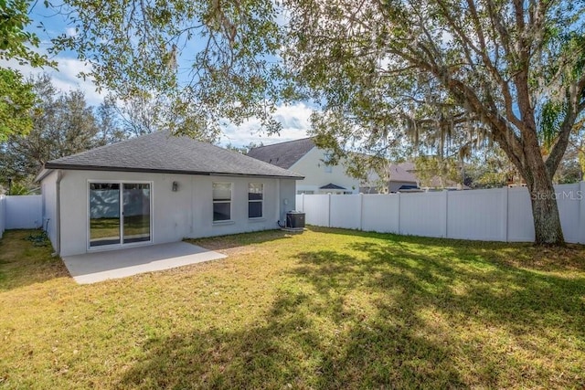 back of property with cooling unit, a yard, and a patio area