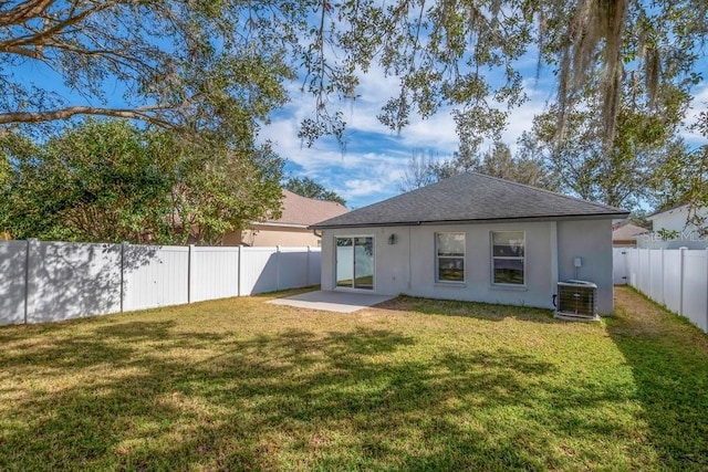 back of house with central AC unit, a patio area, and a lawn