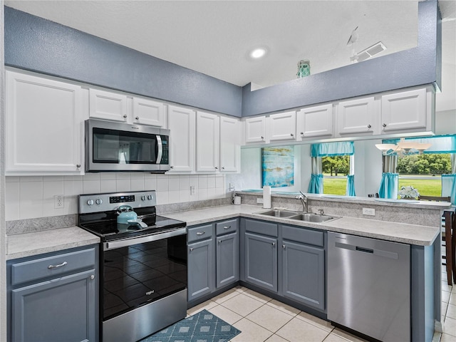 kitchen featuring gray cabinets, sink, stainless steel appliances, and white cabinetry