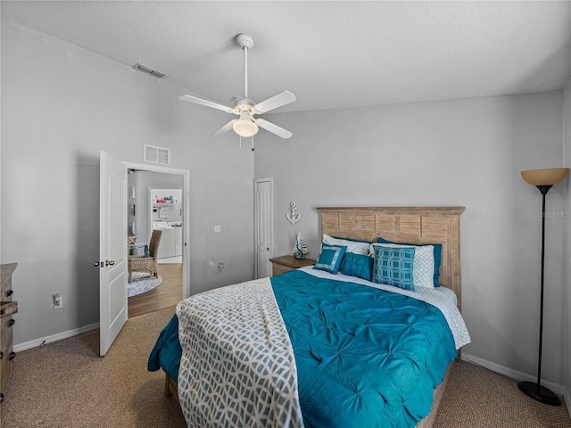 carpeted bedroom featuring lofted ceiling, ceiling fan, and a textured ceiling