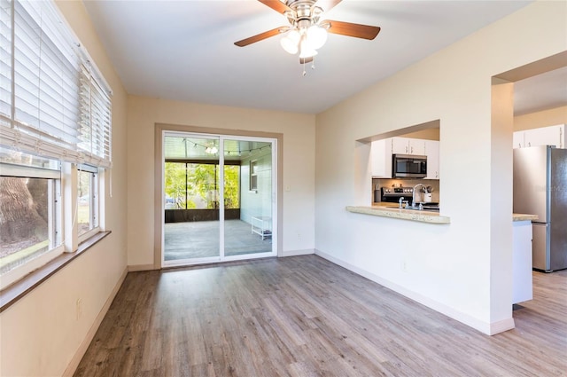 unfurnished living room with ceiling fan and light hardwood / wood-style flooring