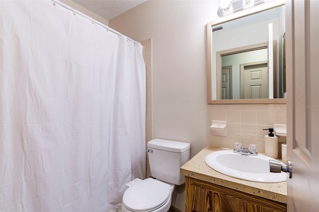 bathroom featuring toilet, vanity, a textured ceiling, and decorative backsplash