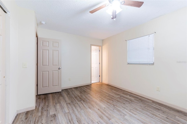 unfurnished bedroom featuring ceiling fan, light hardwood / wood-style floors, and a textured ceiling