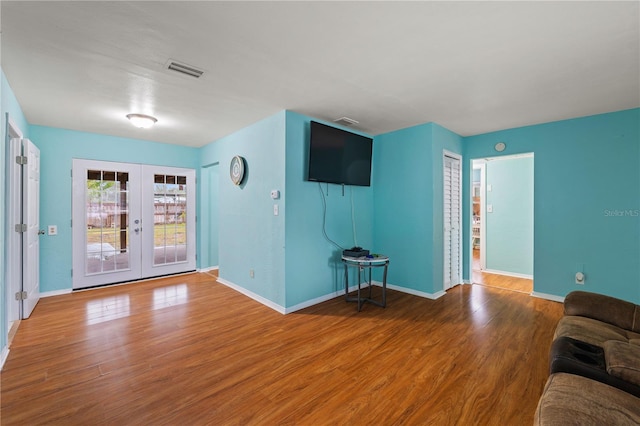 unfurnished living room with hardwood / wood-style flooring and french doors